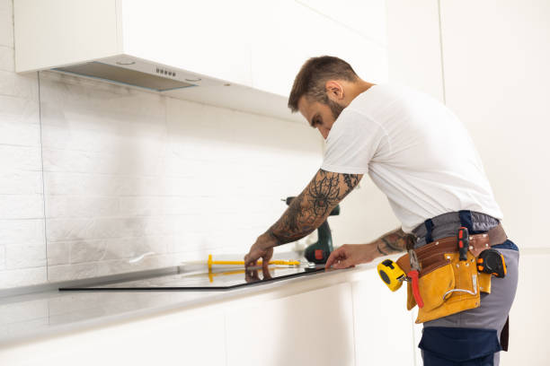 istock Man electrical repairs kitchen surface apartment. Installing hob in countertop. Man bought new kitchen furniture and appliances. Process installing an electrician household appliances. 1482766876