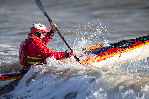 Small group of men and women floating in a river after their raft flipped over while white water river rafting