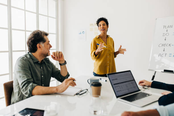istock Professional woman discusses a project with her team 1482769056