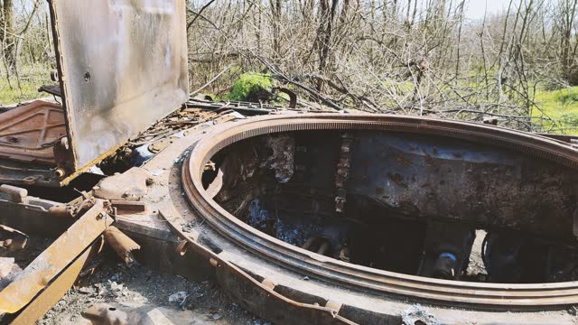 Russian tank destroyed by the Ukrainian military during the invasion of Ukraine. The remains of a blown up Russian tank in the Kherson region, Ukraine 2022 - 2023. The tank is covered with rust and begins to overgrow with plants.