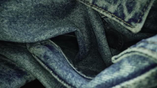 Macro shot of blue denim jeans material. Slider dolly extreme close-up of clothing material. stock video