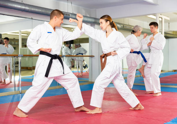istock Woman and man in kimono and belts fighting during karate training 1482773176
