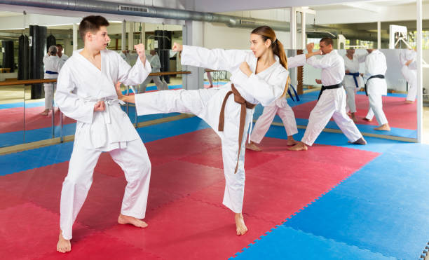 istock Teenage boy and woman sparring during group karate training 1482773214