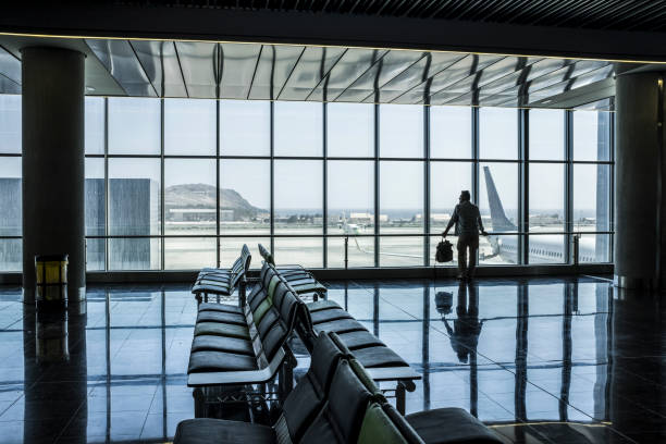 istock Empty airport gate with one man standing and waiting his flight looking outside the windows at the aircrafts. People and travel concept lifestlyle. Tourist wait to leave and go to destination. Journey 1482774675