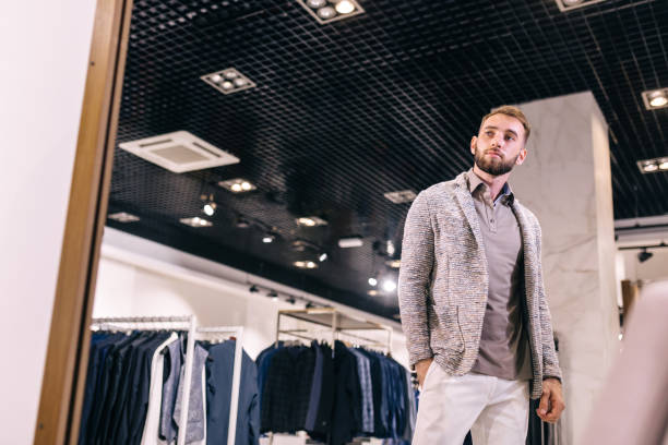 istock Handsome man trying on stylish clothes in a store 1482775703