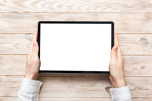 female teen hands using tablet pc with white screen, Mockup image of woman hand holding white tablet pc with blank white screen at home.