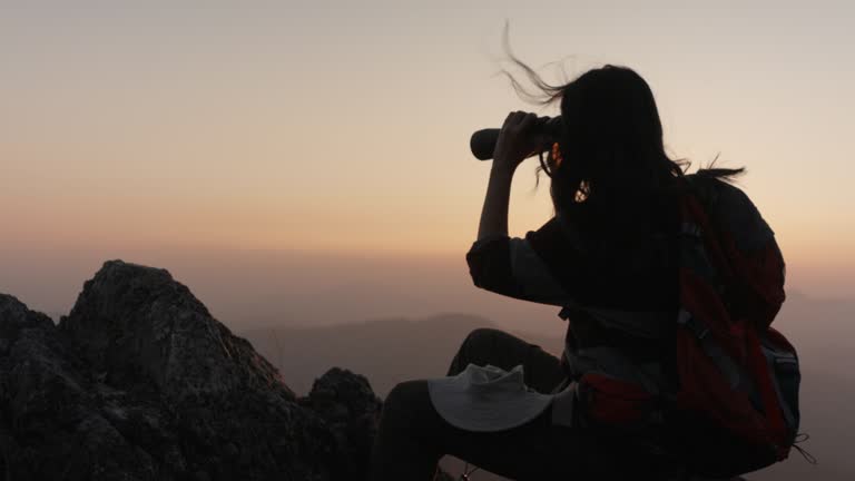 Asia woman backpacker using binoculars look beautiful landscape