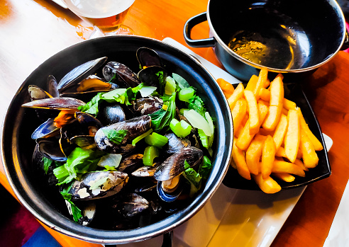 A closeup of a delicious steamed mussel casserole in a Belgian restaurant. Healthy food.