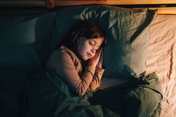 high angle view of a little girl sleeping in her bed at night - sleeping child bedtime little girls imagens e fotografias de stock