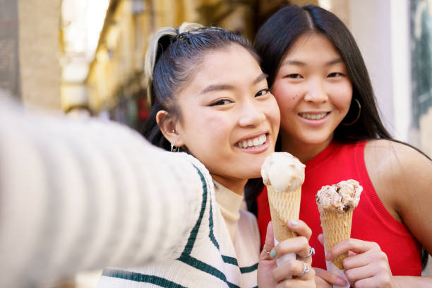 istock Happy Asian girlfriends taking selfie with ice creams 1482788708