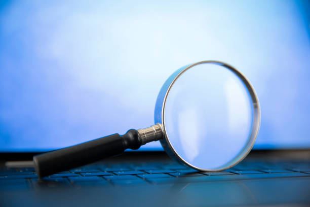 istock Magnifying Glass on Top of Computer Keyboard 1482792364