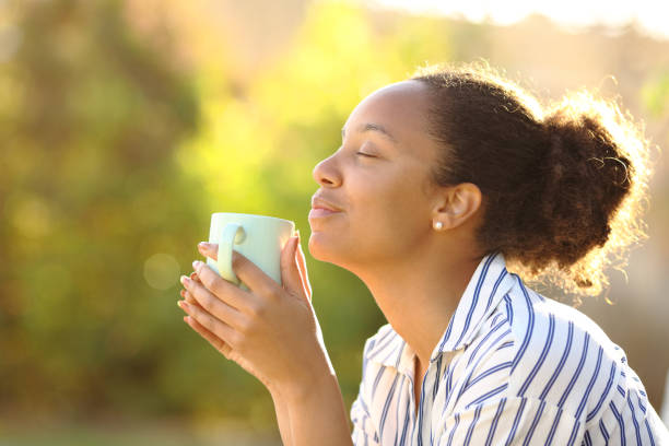 istock Relaxed black woman drinking coffee and smelling 1482792440