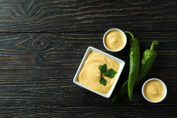 istock Bowls with cheese sauce and pepper on wooden table 1482792784