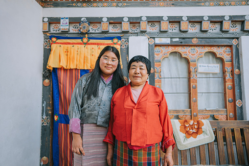 Bhutanese grandmother and granddaughter portrait looking at camera smiling