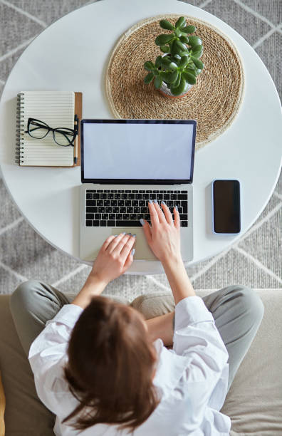 istock Mockup white screen laptop woman using computer sitting on sofa at home, top view 1482797163