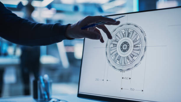 istock Close Up of a Desktop Computer Monitor Screen with 3D CAD Software with Prototype Jet Engine Project. Specialist Discussing Work, His Hands Visible In Front of the Screen. 1482799799