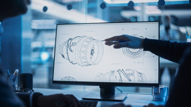 istock Close Up of a Desktop Computer Monitor Screen with 3D CAD Software with Prototype Jet Engine Project. Two Specialists Discussing Work, Their Hands Visible In Front of the Screen. 1482799807