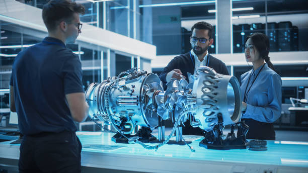 istock Diverse Multiethnic Team of Industrial Engineers Gathered Around a Table With a Prototype Turbine Engine. Scientists Use Tablet Computer to Research, Develop and Program the Futuristic Motor. 1482799979