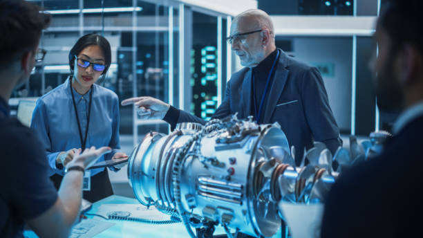 istock Diverse Multiethnic Team of Industrial Engineers Gathered Around a Table With a Prototype Turbine Engine. Scientists Use Tablet Computer to Research, Develop and Program the Futuristic Motor. 1482800008