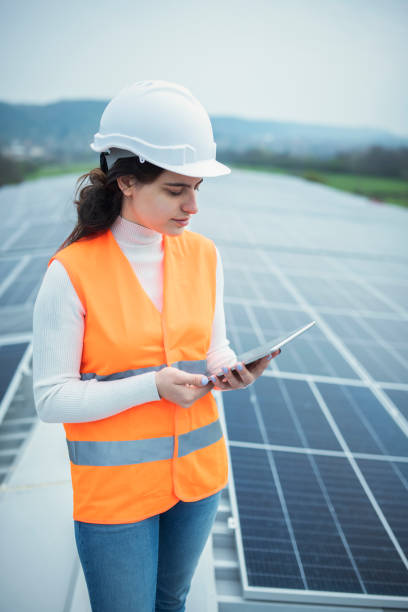 istock Young female electrician/engineer checking on solar panels and using digital tablet. 1482800817