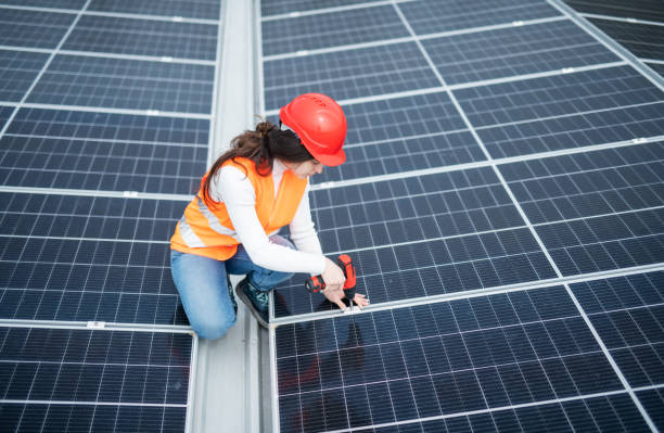 istock Female technician using a drill to repair solar panels. 1482800828