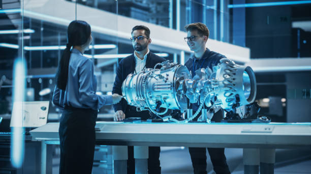 istock Smart Team of Engineers, Project Manager and Machinery Operators Collaborate on a New Type of a Electric Turbine Engine, Standing with Tablet and Laptop Computers in Scientific Technology Lab. 1482801518