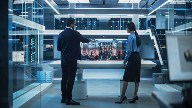 istock Two Diverse Engineers Working in High Tech Research Facility with a Futuristic Turbine Motor. Project Leader Explaining How the Prototype Engine Works to an Industrial Specialist with a Laptop. 1482801832