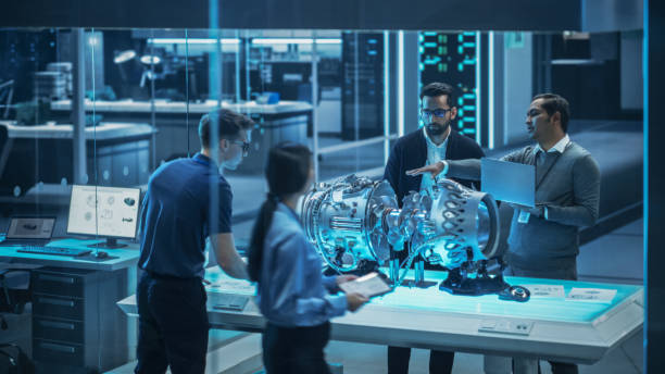 istock Young Team of Engineers, Project Manager and Machinery Operators Collaborate on a New Type of a Gas Turbine Engine, Standing with Tablet and Laptop Computers in Scientific Technology Lab. High Angle. 1482802661