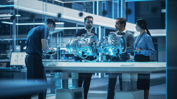 istock Young Team of Engineers, Project Manager and Machinery Operators Collaborate on a New Type of a Gas Turbine Engine, Standing with Tablet and Laptop Computers in Scientific Technology Lab. High Angle. 1482802683