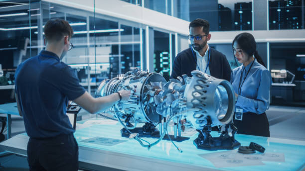 istock Young Team of Multicultural Engineers Use Blueprints, Tablet and Laptop Computers, Analyze and Discuss How a Modern Electric Turbine Motor Works. High Tech Research Laboratory with Modern Equipment. 1482802848