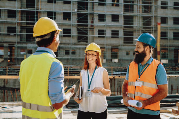 istock Female architect talking to engineer and contractor on construction site 1482802890