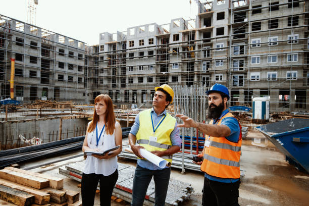 istock Architects meeting with contractor at the construction site, surrounded by concrete and cranes 1482802925