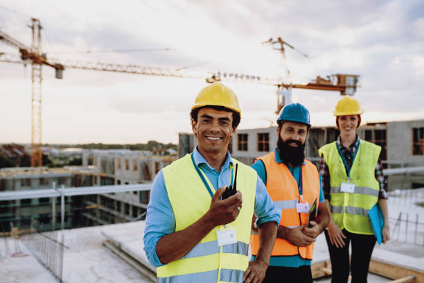 istock Construction employees looking at camera, while standing on the top of the building 1482802985