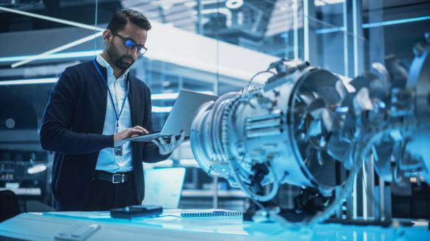 istock Chief Engineer Using Laptop Computer, Analyzing and Researching How a Futuristic Turbofan Motor Works. Senior Manager Developing Innovative Technology in Industrial High Tech Facility. 1482804657