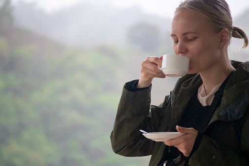 Beautiful Woman Drinking Tea in Tea Plantation in Cameron Highlands, Malaysia.