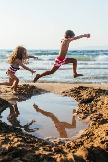 istock Children jumping over pond at the beach 1482806706