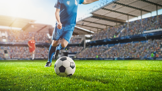 Football World Championship: Soccer Player Runs to Kick the Ball. Ball on the Grass Field of Arena, Full Stadium Crowd Cheers. International Tournament Concept. Cinematic Shot Captures Victory.