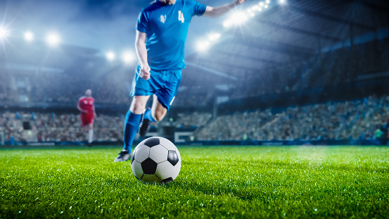 Football World Championship: Soccer Player Runs to Kick the Ball. Ball on the Grass Field of Arena, Full Stadium of Crowd Cheers. International Tournament. Cinematic Shot Captures Flawless Victory.