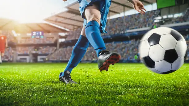 Football World Championship: Soccer Player Runs, Kicks the Ball. Ball Shoots, Grass Sprays Outwards, Full Stadium Crowd Cheers. Cinematic Shot Captures Glorious Victory. International Tournament.