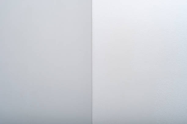 istock Background with light walls covered with white paint. Selective focus on part of the wall. White geometric backdrop with sharp corners. 1482806905