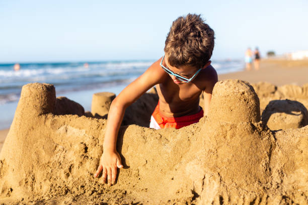 istock Boy building a sand castle on the beach 1482806927