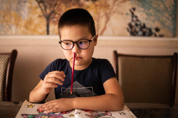 A bored little boy student inserted a pencil into his nose. The concept of ADHD stock photo