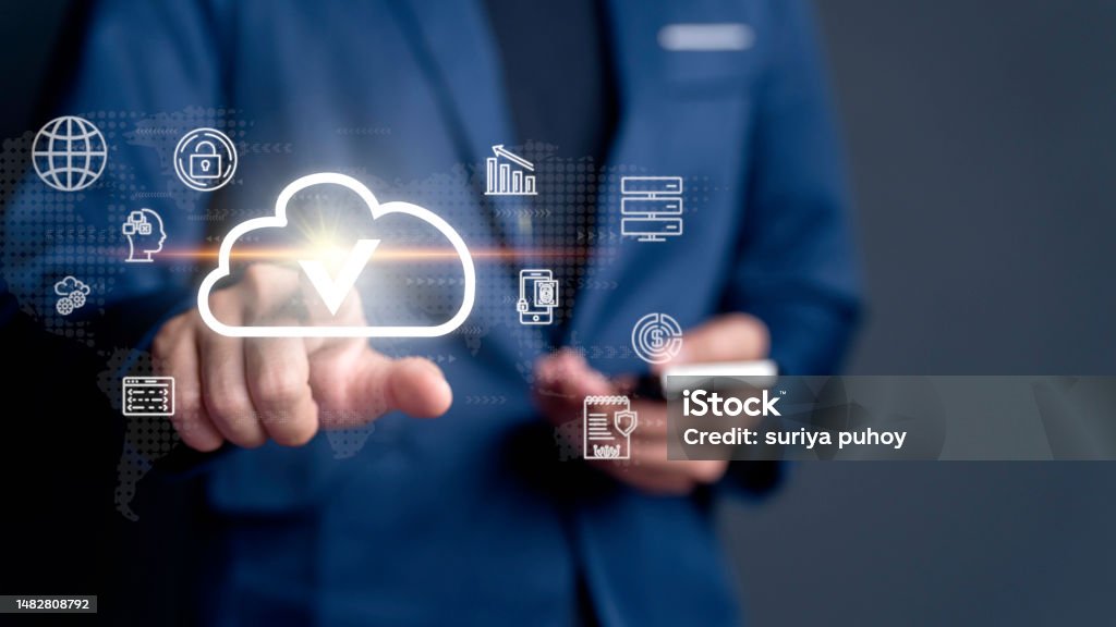 businessman taps on a cloud symbol displayed on device connectivity and the implementation of advanced cloud technology systems for optimized data storage resource management, fast-paced digital work. Accessibility Stock Photo