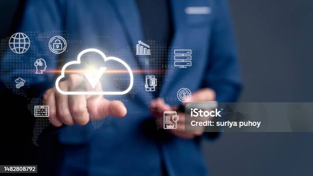Businessman Taps On A Cloud Symbol Displayed On Device Connectivity And The Implementation Of Advanced Cloud Technology Systems For Optimized Data Storage Resource Management Fastpaced Digital Work Stock Photo - Download Image Now