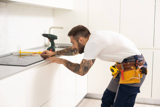 istock Man electrical repairs kitchen surface apartment. Installing hob in countertop. Man bought new kitchen furniture and appliances. Process installing an electrician household appliances. 1482809097