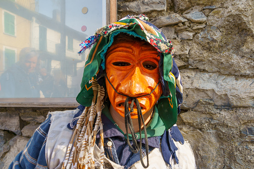 Schignano, Italy - February 18, 2023: Participant in traditional costume and mask, part of the traditional carnival of Schignano, Lake Como, Lombardy, Northern Italy