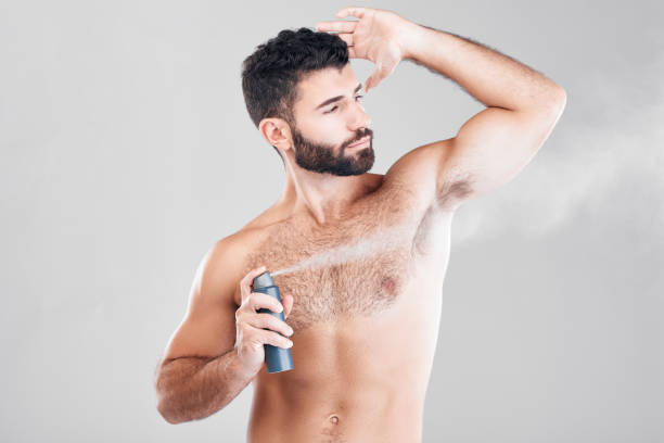 istock Spray, deodorant and man with cosmetics, morning routine or grooming on grey studio background. Male, perfume or fragrance for fresh scent, self care or hygiene with guy or antiperspirant on backdrop 1482810874