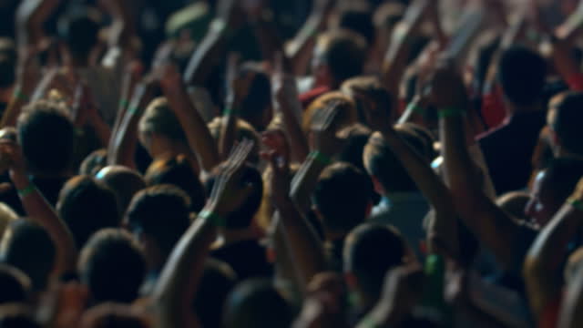 Crowd on a music festival. Hands in the air. Colorful illuminations