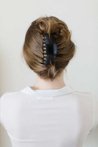 A young woman with her hair pulled back elegantly in a claw clip. Trendy hairstyle.