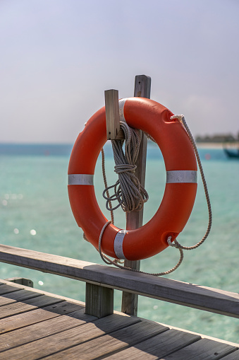 Lifebuoy on a background of blue water at the pier in the Maldives.